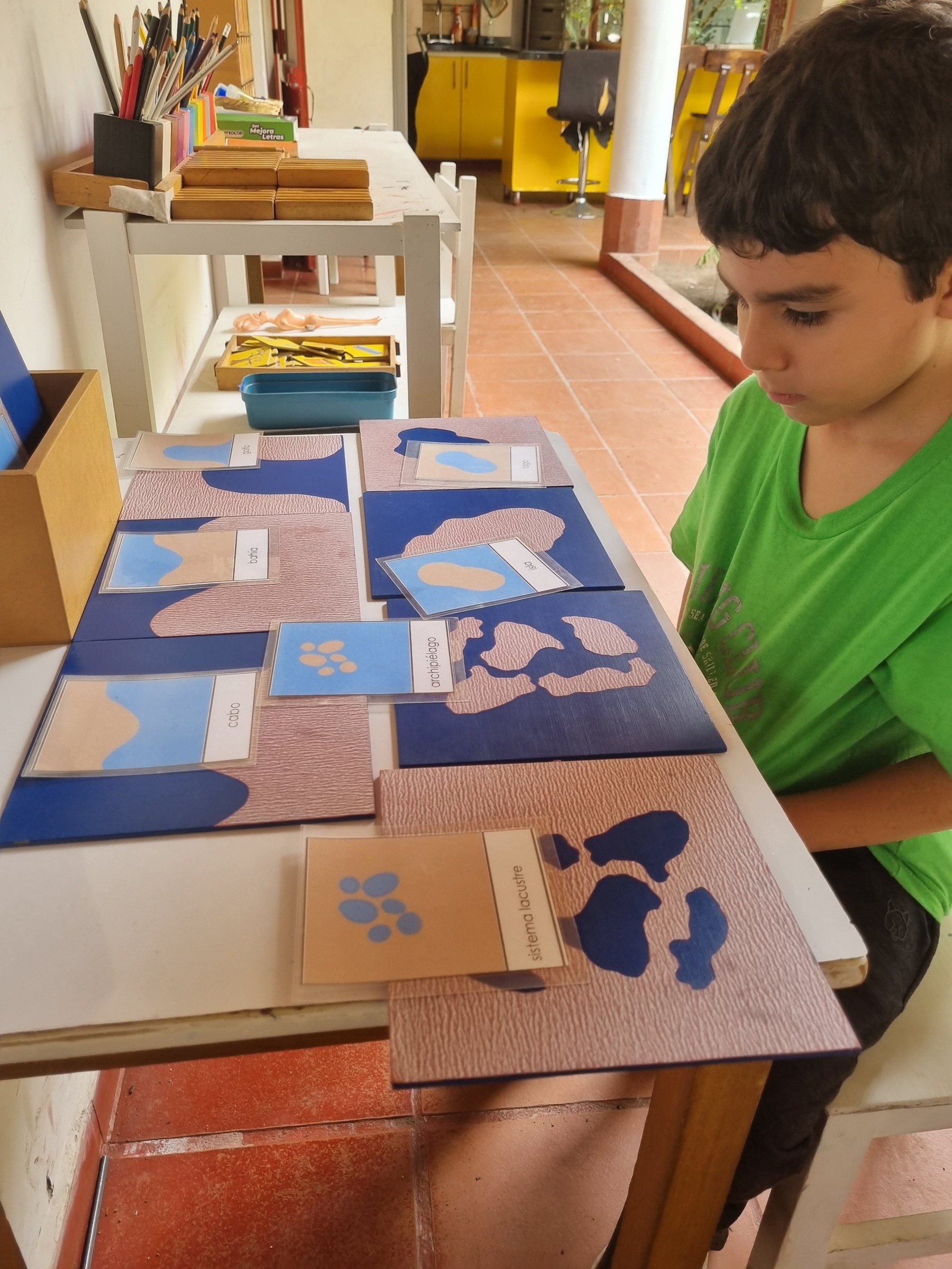 Estudiante explora tarjetas sensoriales dispuestas sobre una mesa.